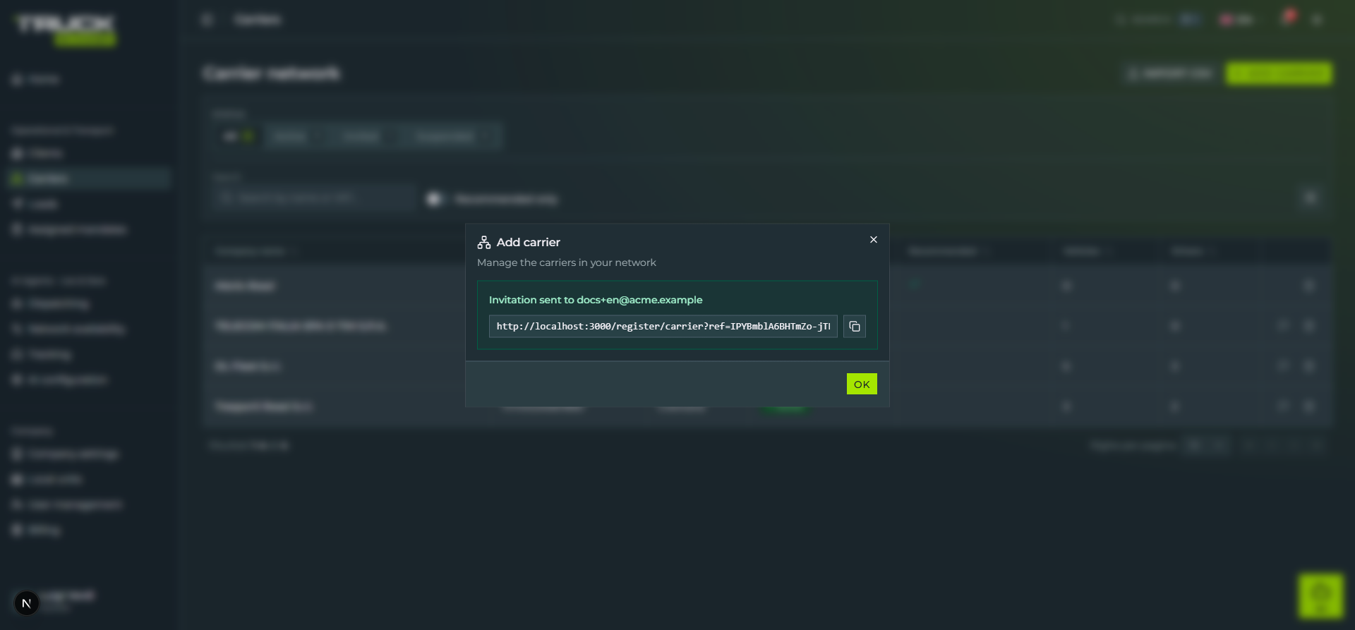 The «Add carrier» dialog after sending the invitation: green card «Invitation sent to docs+en@acme.example», below a read-only input with the registration link `http://localhost:3000/register/carrier?ref=...` and a copy icon on the right, lime «OK» button at the bottom